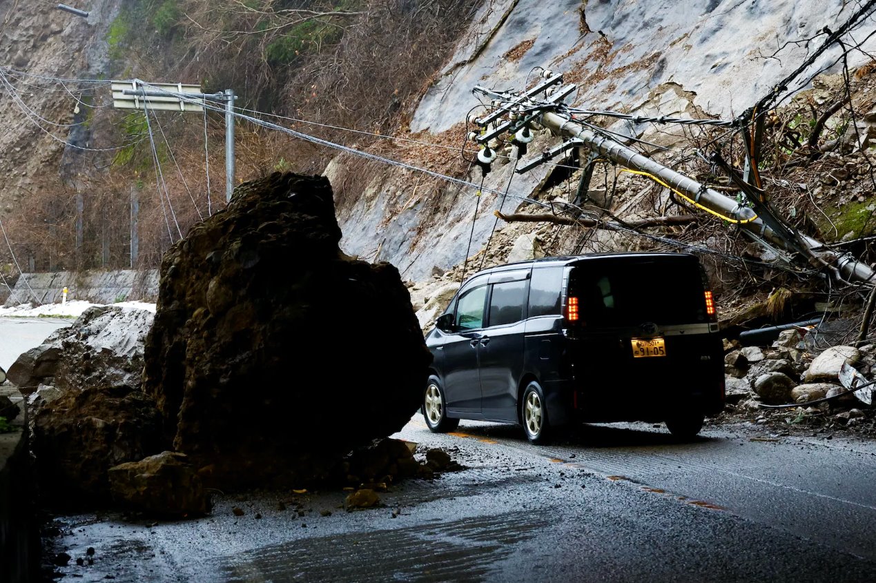 2024年1月3日，日本輪島，地震后，一輛汽車(chē)在受損的道路上行駛。