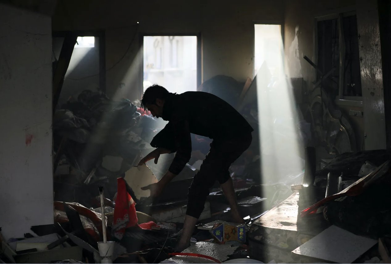 2024年1月3日，巴勒斯坦人在以色列襲擊加沙地帶中部馬加齊難民營的現(xiàn)場撿拾殘骸。