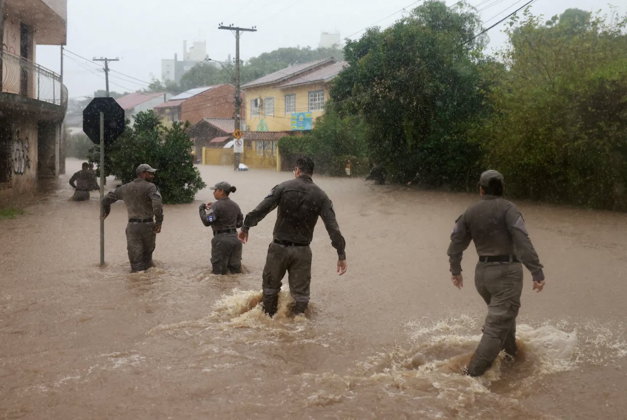 2024年5月23日，巴西阿雷格里港暴雨后，巴西軍警在卡瓦利亞達(dá)附近的洪水地區(qū)搜尋民眾。