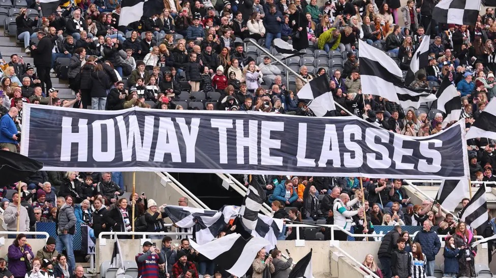 紐卡斯?fàn)柷蛎栽谑フ材匪构珗@舉著寫有&ldquo;Howay the Lasses&rdquo;的橫幅