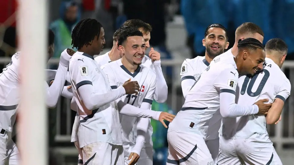 瑞士隊在2026年世界杯預(yù)選賽中保持不敗，戰(zhàn)績?yōu)樗膭賰善健? /></p>
<p>溫州網(wǎng)體育新聞，瑞士隊以不敗戰(zhàn)績鎖定2026年世界杯參賽資格，在普里什蒂納頂住了科索沃隊的最后反撲，最終與對手戰(zhàn)平。</p>
<p>上半場雙方表現(xiàn)平平，第47分鐘，魯本&middot;巴爾加斯接應(yīng)吉布里爾&middot;索烏的精準(zhǔn)傳球，從后場溜入禁區(qū)，將球送入科索沃門將阿里賈內(nèi)特&middot;穆里奇把守的球門。</p>
<p>但弗洛倫特&middot;穆斯利亞在第74分鐘以一記精彩的弧線球射門將球送入球門右上角，扳平了比分。</p>
<p>主隊在比賽尾聲階段全力爭取制勝，巴頓&middot;扎貝里賈和韋達(dá)特&middot;穆里奇的射門都被門將格雷戈爾&middot;科貝爾撲出。</p>
<p>瑞士隊需要贏球或打平才能自動獲得明年比賽的參賽資格，而科索沃隊即使贏球也可能不夠，因為瑞士隊的凈勝球優(yōu)勢非常明顯。</p>
<p>這一結(jié)果意味著瑞士隊以14分位列B組榜首，而力爭首次晉級世界杯的科索沃隊以11分位列第二，并將參加3月份的歐洲區(qū)附加賽。</p>　　本文“世預(yù)賽足球新聞”來源：http://m.zjjzhonglv.com/sports/7384.html，轉(zhuǎn)載必須保留網(wǎng)址。
      <div   id=